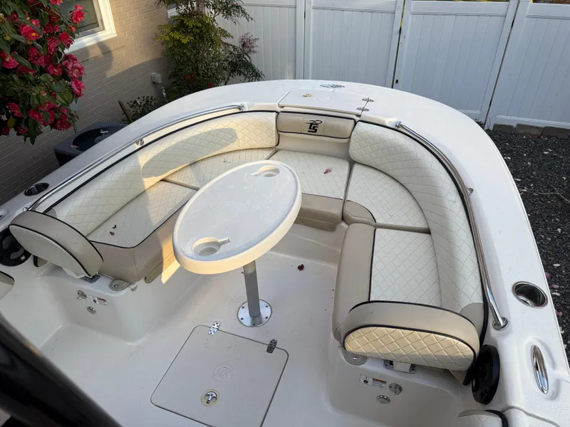 Slide: The Image of 2021 Carolina Skiff 23 Ultra Elite boat interior with cushioned seating and round table. - 12