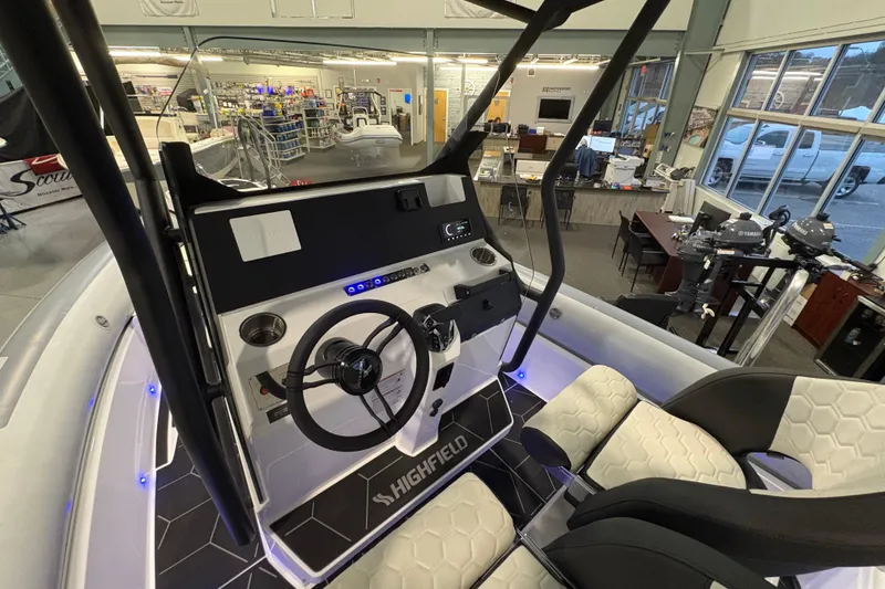 Slide: The Image of 2026 Highfield ADV7 boat interior with steering console and seating in showroom. - 12