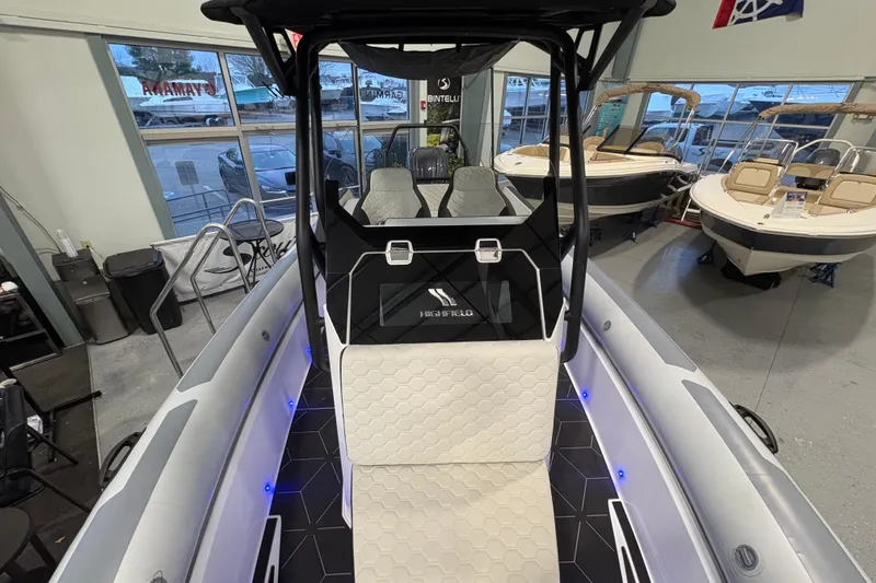 Slide: The Image of 2026 Highfield ADV7 boat interior with modern seating and sleek design in showroom. - 25