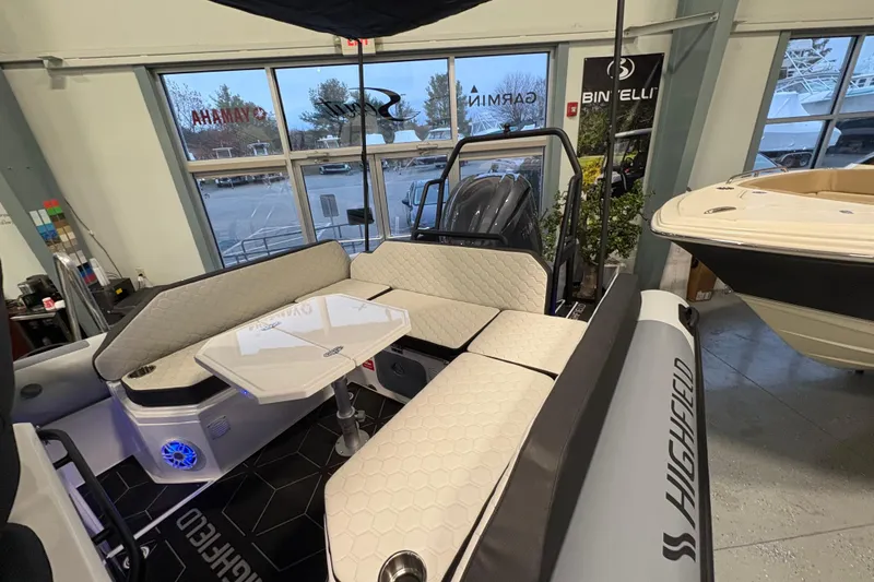 Slide: The Image of 2026 Highfield ADV7 boat interior with cushioned seating and table in showroom. - 5