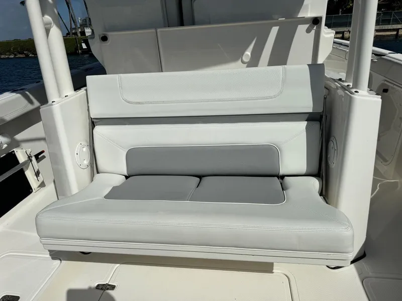 Slide: The Image of 2022 Pursuit S 328 Sport boat seating, white and gray upholstery, outdoor setting. - 13