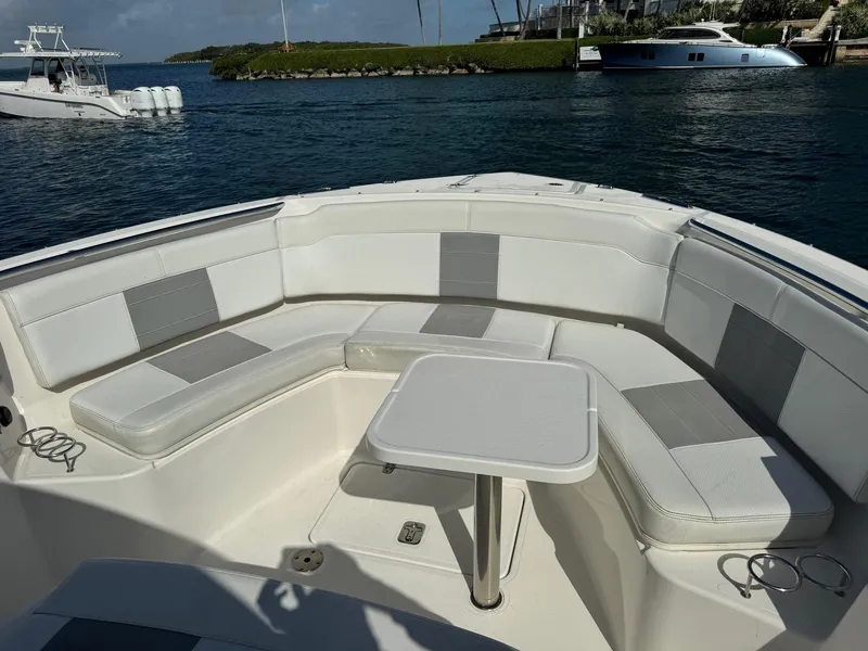 Slide: The Image of 2022 Pursuit S 328 Sport boat with cushioned seating and table on deck. - 5