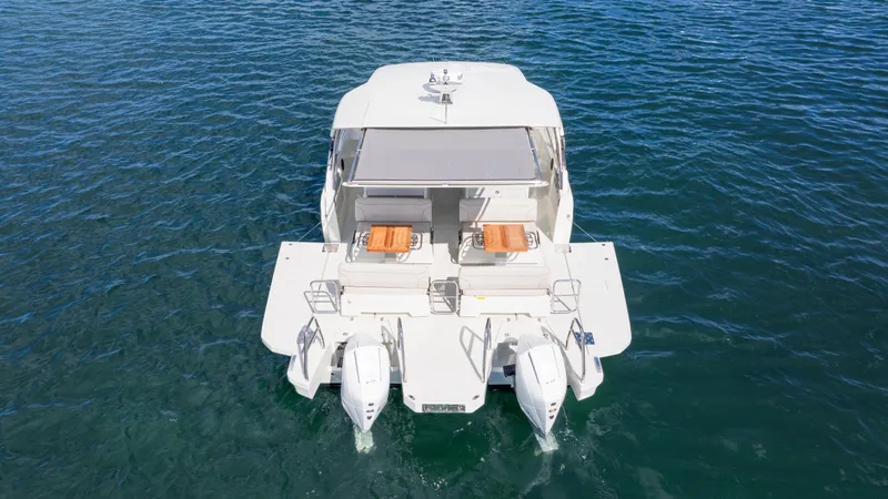 Slide: The Image of 2025 YOT 36 boat on water, rear view with twin engines and deck seating. - 13