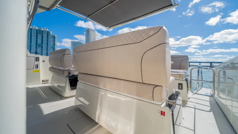 Slide: The Image of Luxurious YOT 36 yacht deck with modern seating, city skyline, and blue sky, 2025 model. - 18