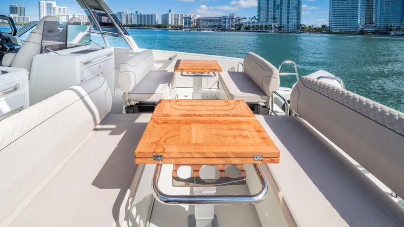 Slide: The Image of Luxurious 2025 YOT 36 yacht with elegant seating and wooden tables, overlooking a scenic waterfront. - 19