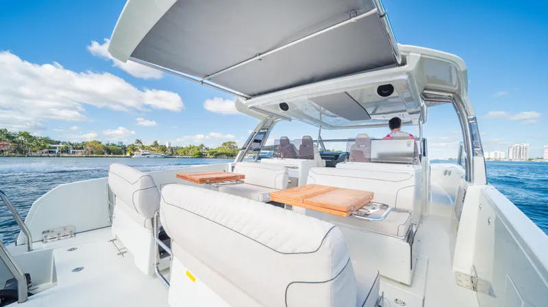 Slide: The Image of 2025 YOT 36 boat with spacious deck, luxury seating, and canopy on open water. - 21