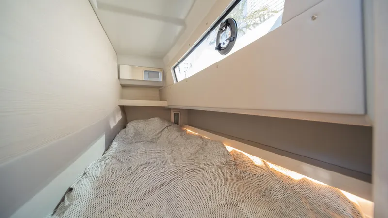 Slide: The Image of Cozy interior cabin of 2025 YOT 36 boat with window and bedding. - 36
