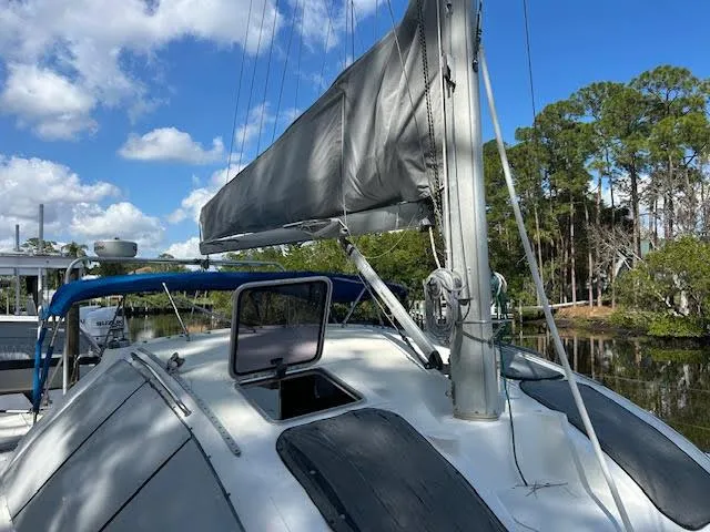 Slide: The Image of Sailboat Lagoon TPI 37, 1995 model, docked with trees and blue sky in the background. - 1