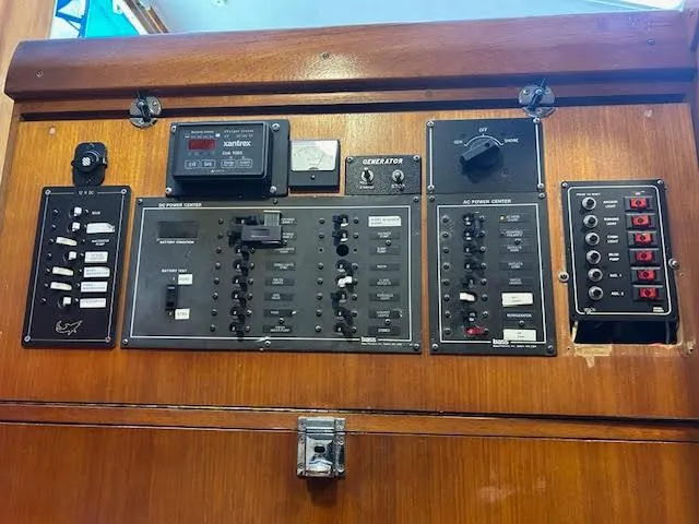 Slide: The Image of Control panel of a 1995 Lagoon TPI 37 yacht with various switches and gauges. - 16