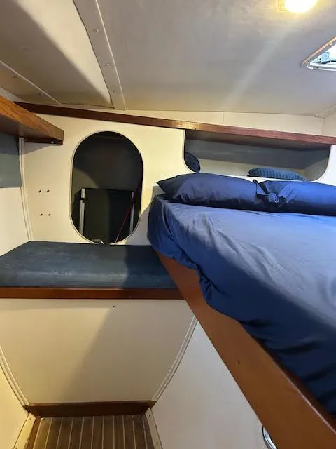 Slide: The Image of Interior cabin of 1995 Lagoon TPI 37 sailboat with blue bedding and wooden accents. - 19