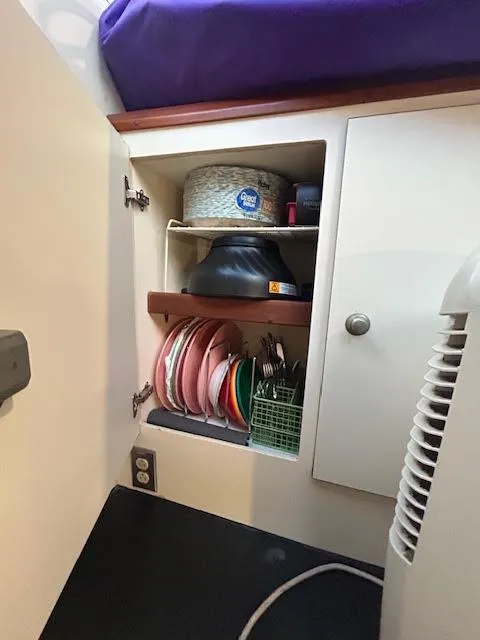 Slide: The Image of Cabinet interior with dishes and storage on a 1995 Lagoon TPI 37 boat. - 21