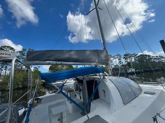 Slide: The Image of 1995 Lagoon TPI 37 sailboat with blue canopy, docked under a clear sky. - 3