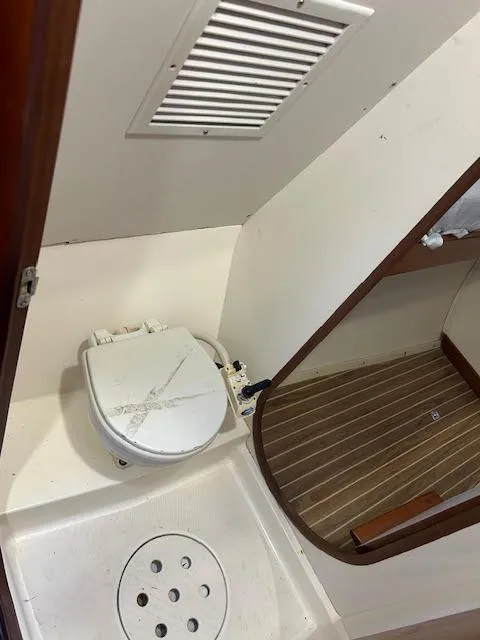 Slide: The Image of 1995 Lagoon TPI 37 boat bathroom with toilet and wooden floor. - 34