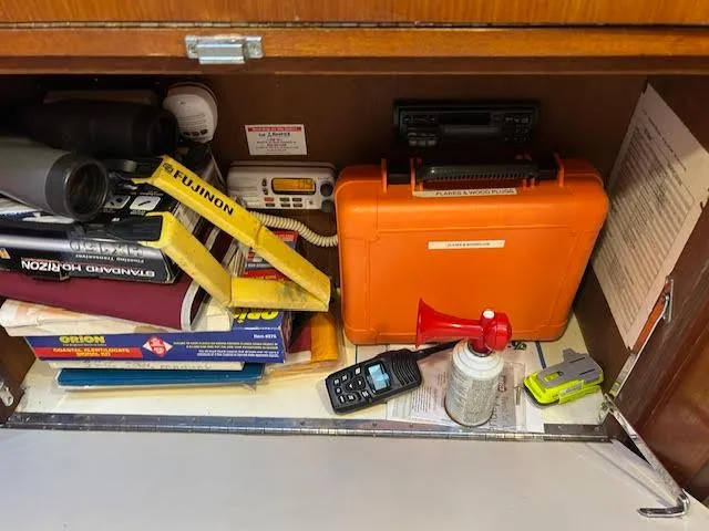 Slide: The Image of Storage compartment on a 1995 Lagoon TPI 37 with safety equipment and navigation tools. - 45