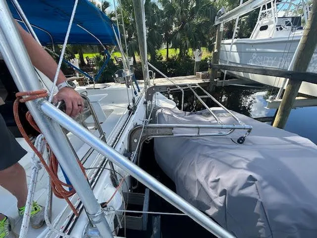 Slide: The Image of 1995 Lagoon TPI 37 sailboat with covered dinghy, docked near palm trees. - 5
