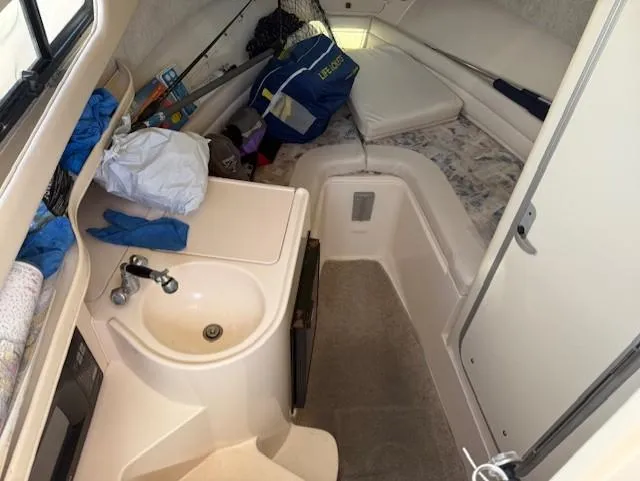 Slide: The Image of 2003 Grady-White Sailfish 282 cabin interior with sink, storage, and seating area. - 16
