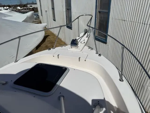 Slide: The Image of 2003 Grady-White Sailfish 282 boat deck with railing and hatch, docked near a building. - 8