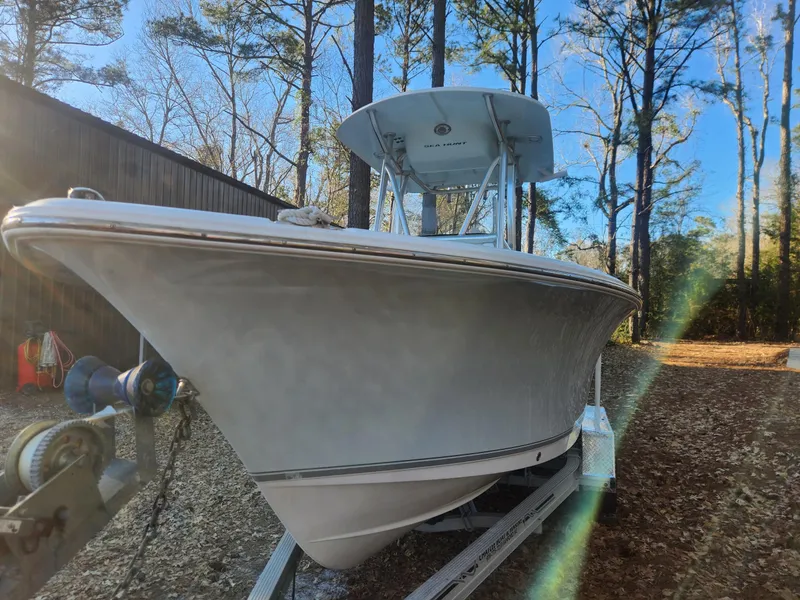 Slide: The Image of 2016 Sea Hunt Ultra 225 boat on trailer in wooded area. - 2