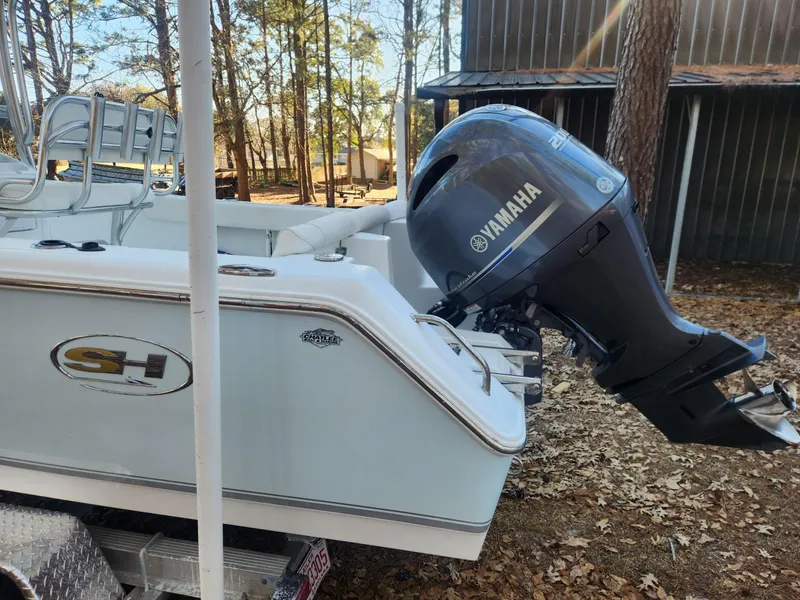 Slide: The Image of 2016 Sea Hunt Ultra 225 boat with Yamaha outboard motor, parked outdoors. - 3
