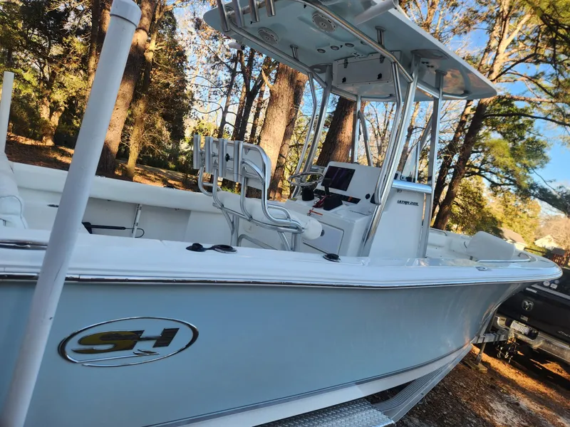 Slide: The Image of 2016 Sea Hunt Ultra 225 boat in wooded area, featuring sleek design and modern console. - 6