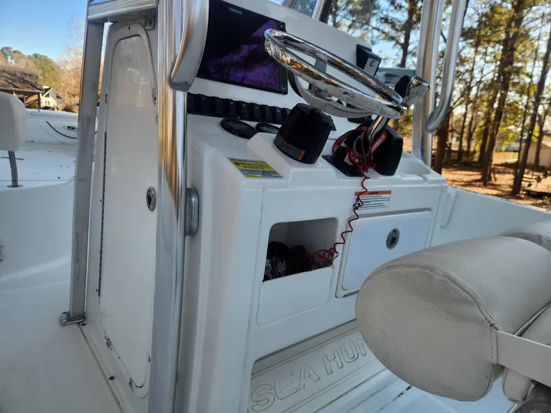 Slide: The Image of 2016 Sea Hunt Ultra 225 boat console with steering wheel and storage compartments. - 9