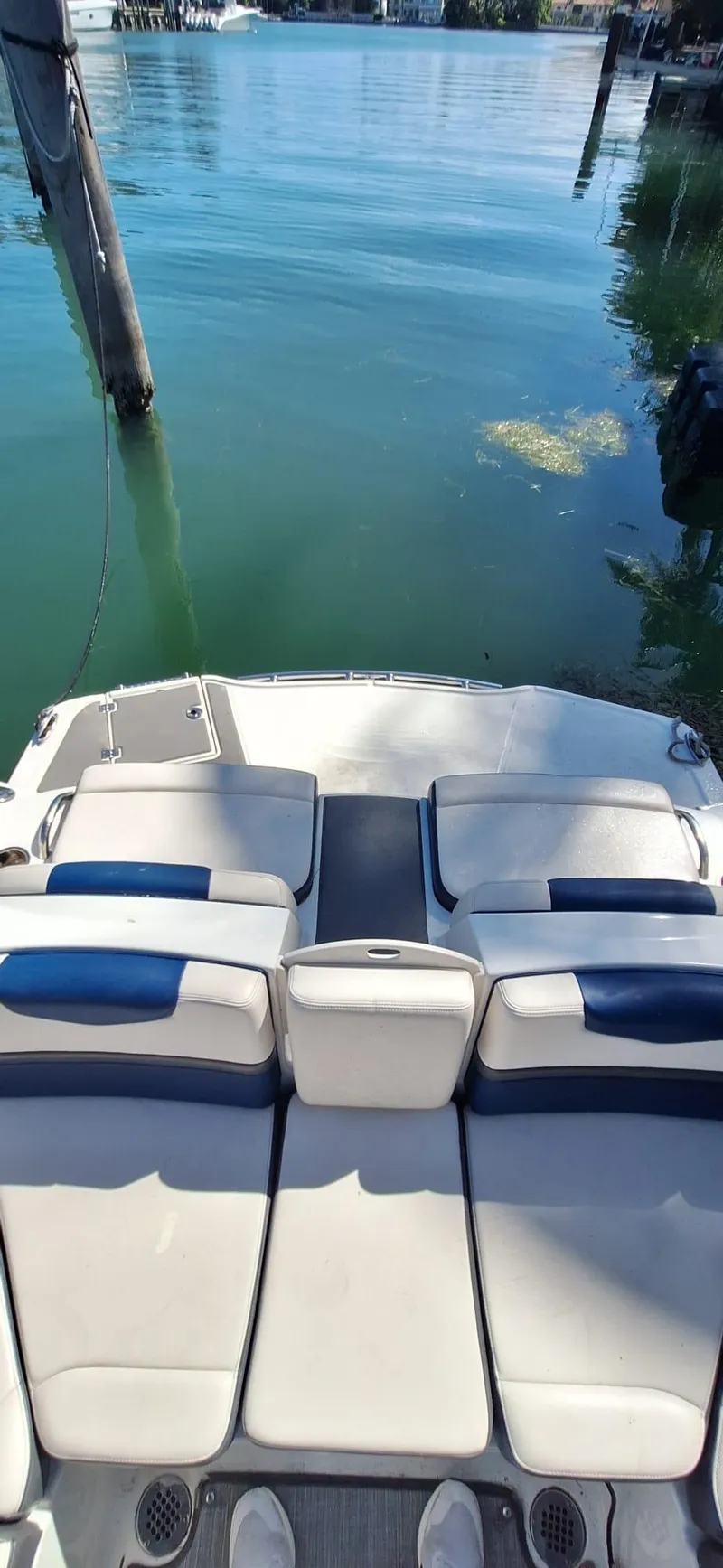 Slide: The Image of 2018 Chaparral Vortex 243 VRX boat with white and blue seating, docked on calm water. - 15