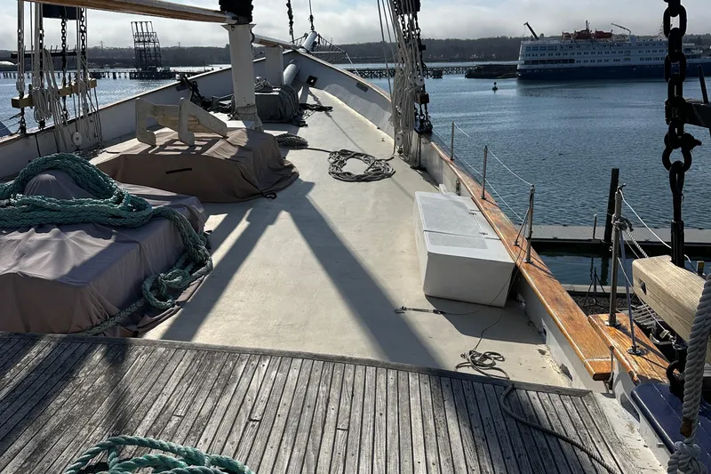 Slide: The Image of Deck of 2006 Schooner HARRIS and BISHOP with ropes and covered equipment, docked by the water. - 17