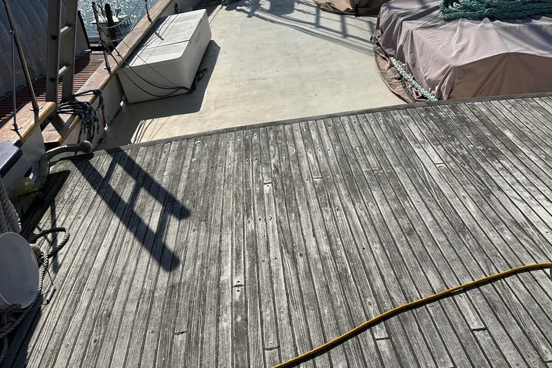 Slide: The Image of Wooden deck of 2006 Schooner HARRIS and BISHOP, featuring ropes and covered equipment. - 22