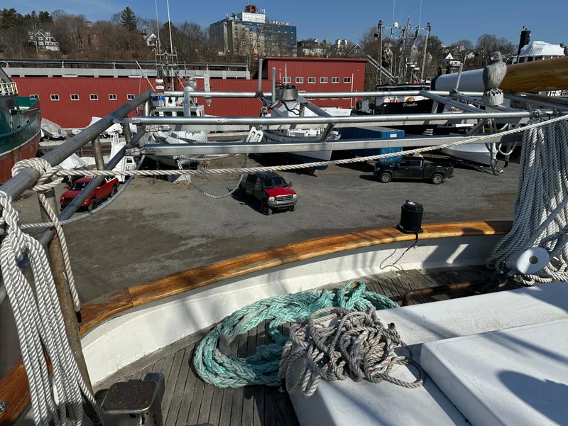 Slide: The Image of Deck view of 2006 Schooner HARRIS and BISHOP in a shipyard with red buildings. - 39
