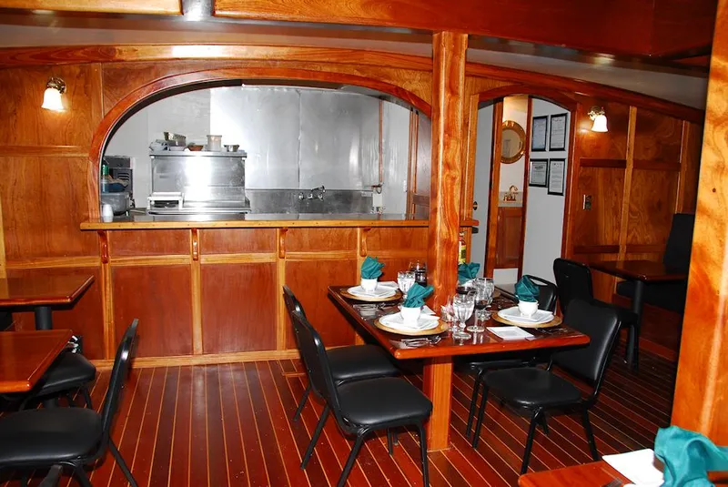 Slide: The Image of Elegant dining area on 2006 Schooner HARRIS and BISHOP with wooden interiors and set tables. - 45