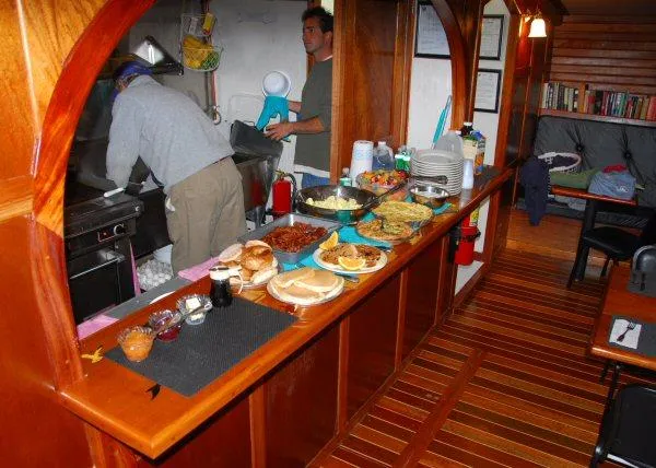 Slide: The Image of Galley of 2006 Schooner HARRIS and BISHOP with food spread and crew preparing meals. - 47