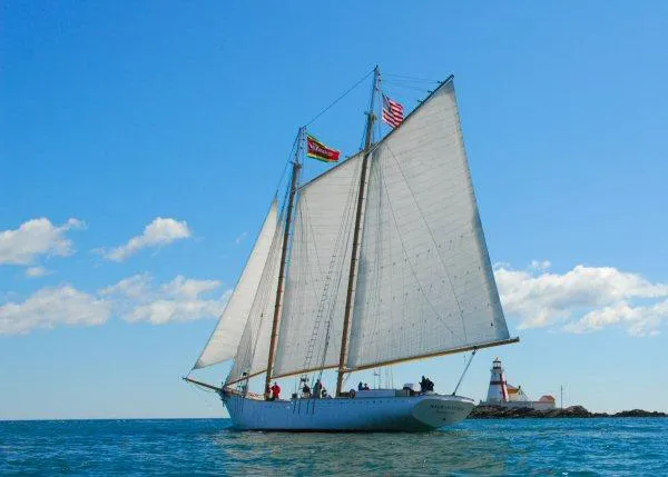 Slide: The Image of Schooner HARRIS and BISHOP 2006 sailing near lighthouse under clear blue sky. - 5
