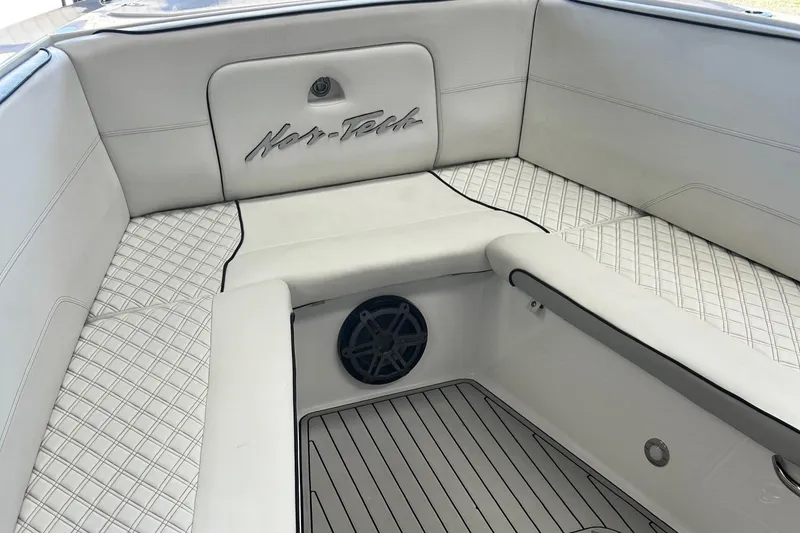 Slide: The Image of 2016 Nor-Tech 390 Sport boat interior with white cushioned seating and speaker. - 14