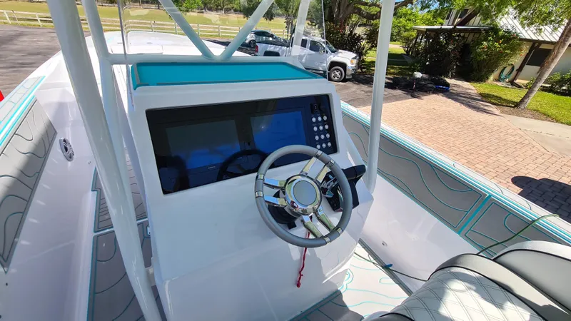 Slide: The Image of 2025 Custom Core 38 Center Console boat interior with modern steering and navigation system. - 14