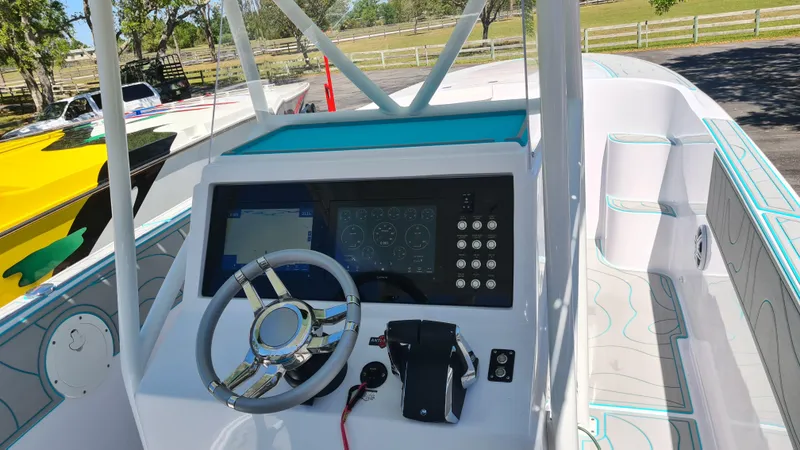 Slide: The Image of 2025 Custom Core 38 Center Console boat dashboard with steering wheel and control panel. - 15