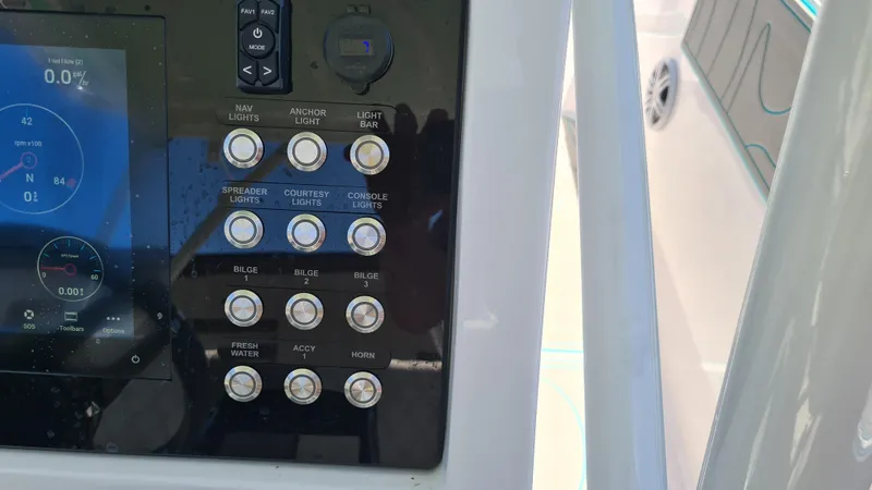 Slide: The Image of Control panel of 2025 Custom Core 38 Center Console boat with various switches and display. - 17
