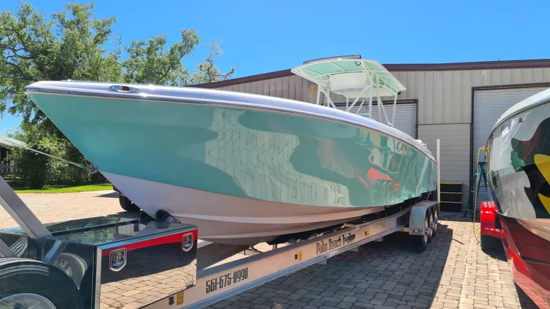 Slide: The Image of 2025 Custom Core 38 Center Console boat on trailer, parked outdoors. - 2