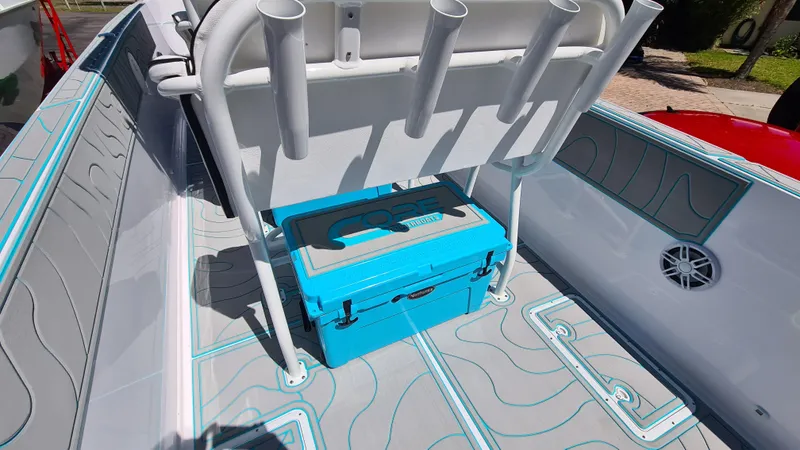 Slide: The Image of 2025 Custom Core 38 Center Console boat interior with blue cooler and rod holders. - 22