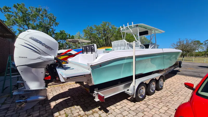 Slide: The Image of 2025 Custom Core 38 Center Console boat on trailer, featuring powerful outboard engine. - 3