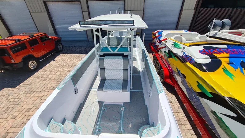 Slide: The Image of 2025 Custom Core 38 Center Console boat in a storage area, alongside colorful speedboats. - 6