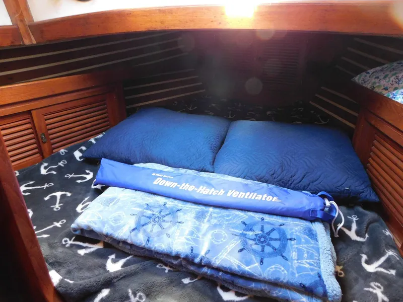 Slide: The Image of Cozy cabin interior of 1984 Tayana 37 sailboat with nautical-themed bedding. - 11
