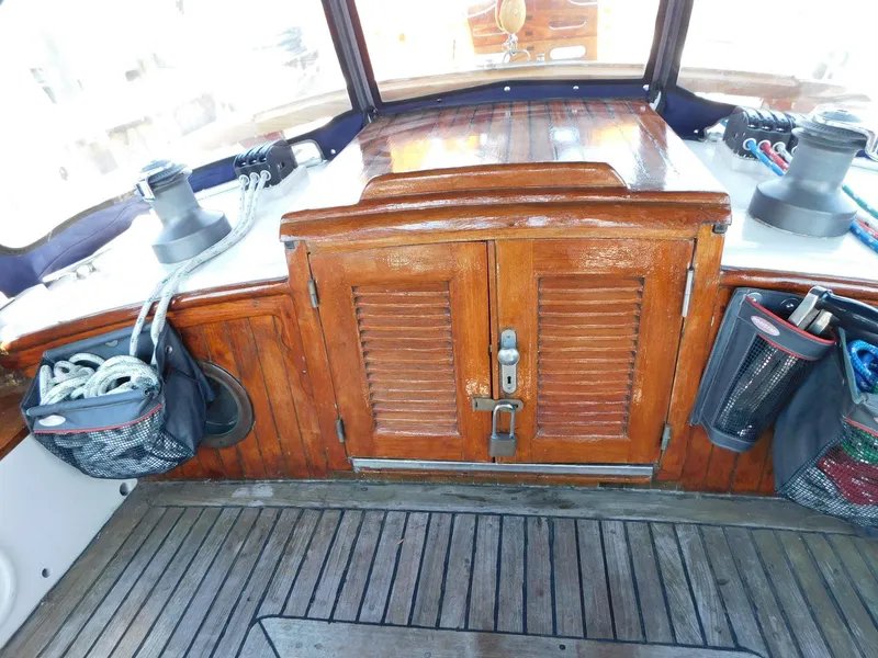 Slide: The Image of 1984 Tayana 37 sailboat cockpit with wooden hatch, winches, and rope storage. - 19