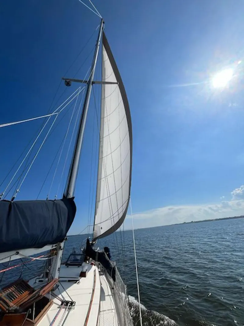 Slide: The Image of 1984 Tayana 37 sailboat cruising under clear blue skies. - 27