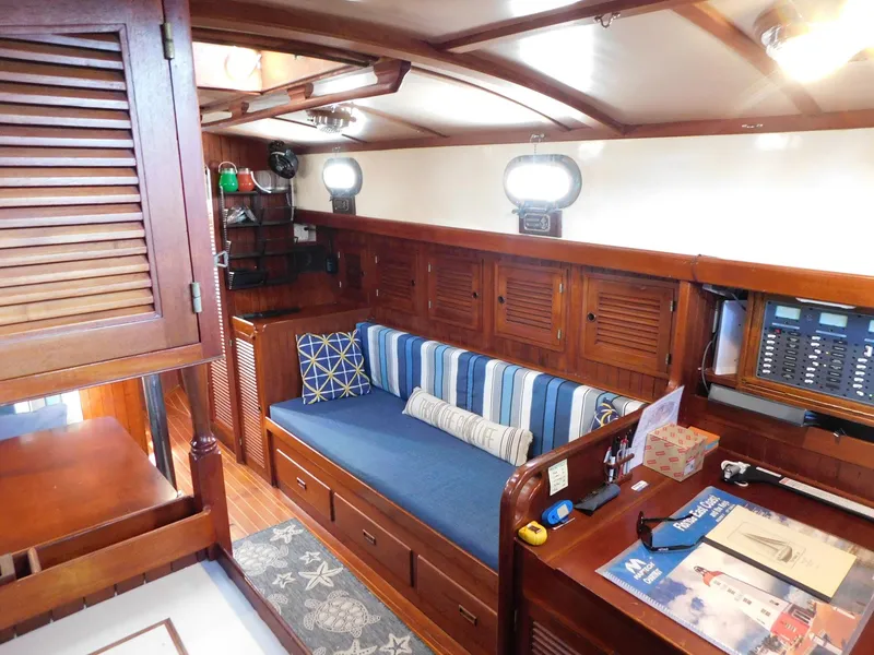 Slide: The Image of Interior of 1984 Tayana 37 sailboat with wooden furnishings and blue-striped seating. - 3