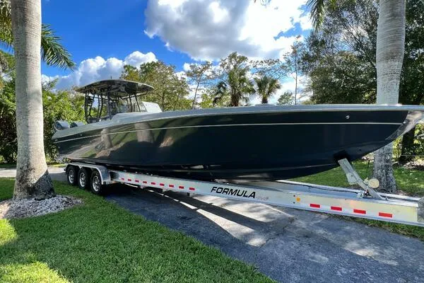 Slide: The Image of 1996 Formula 382 SR1 boat on trailer, parked outdoors under a blue sky. - 2