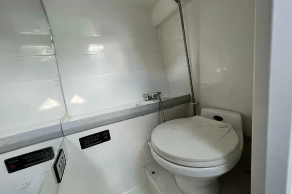 Slide: The Image of 1996 Formula 382 SR1 boat bathroom with white toilet and showerhead. - 20