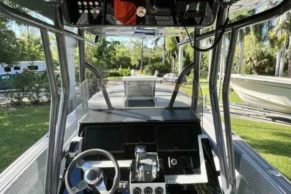 Slide: The Image of 1996 Formula 382 SR1 boat cockpit with steering wheel and control panel, surrounded by lush greenery. - 21