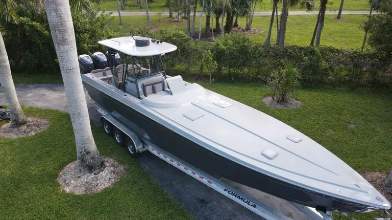 Slide: The Image of 1996 Formula 382 SR1 boat on trailer, parked outdoors near palm trees. - 4