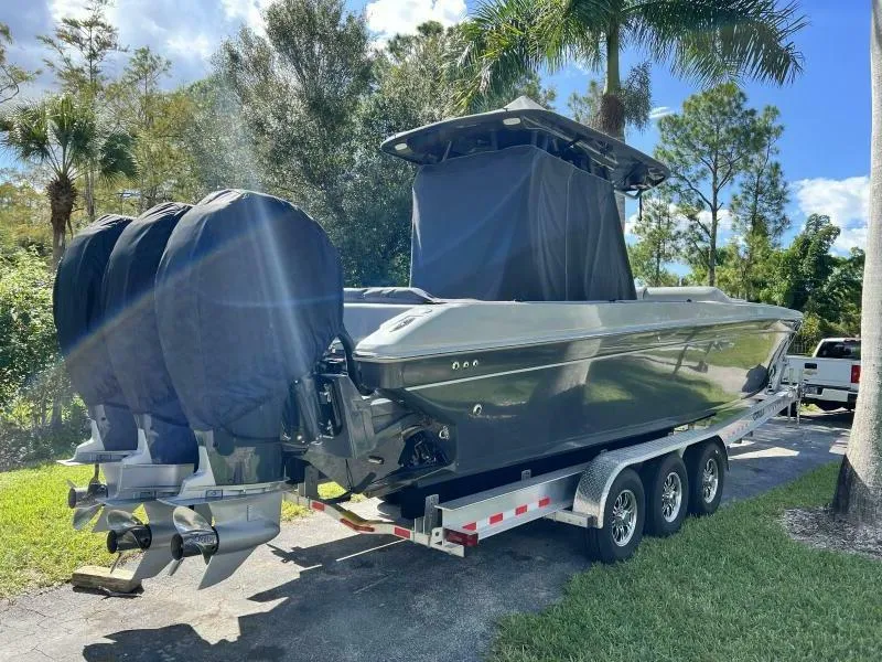 Slide: The Image of 1996 Formula 382 SR1 boat on trailer with triple outboard motors, parked outdoors. - 7