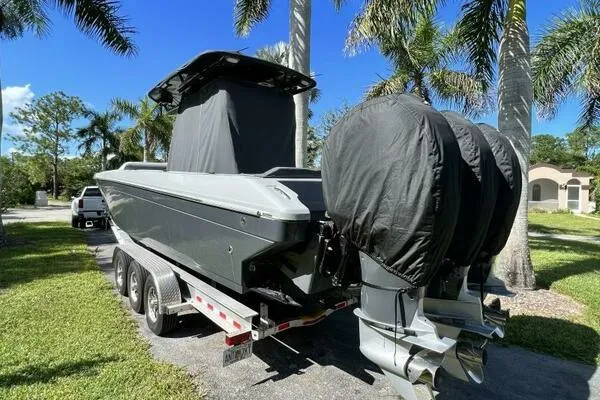 Slide: The Image of 1996 Formula 382 SR1 boat on trailer with covered engines, parked near palm trees. - 9